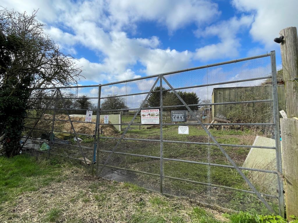 Lot: 125 - EQUESTRIAN SITE WITH FOUR STABLES, HAY BARN, SAND SCHOOL AND DILAPIDATED MOBILE HOME - Gated entrance to equestrian yard